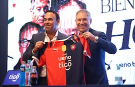 El presidente del Club Cerro Porteño, Blas Reguera (i) y el nuevo director técnico del equipo, Ariel Holan, posan con la camiseta en una conferencia de prensa este miércoles en Asunción (Paraguay).