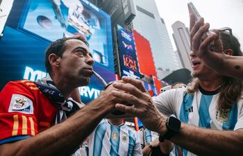 Un hincha argentino le desea suerte a un hincha (izq.) español entre la multitud mientras los hinchas argentinos toman Times Square antes de la final del Mundial, en Nueva York, Estados Unidos, 18 de julio de 2026.