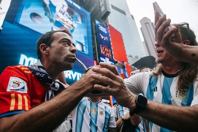 Un hincha argentino le desea suerte a un hincha (izq.) español entre la multitud mientras los hinchas argentinos toman Times Square antes de la final del Mundial, en Nueva York, Estados Unidos, 18 de julio de 2026.