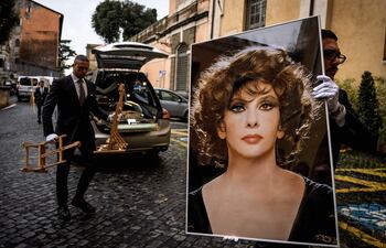 El empleado de una funeraria carga una foto gigante de Gina Lollobrigida, para sus funerales.