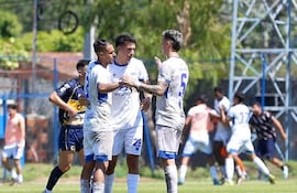 Componentes del bloque defensivo del Independiente de Campo Grande festejan uno de los goles, mientras en el fondo se desata la verdadera "locura" por la conversión.