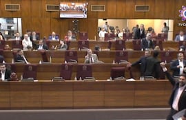 Mauricio Fabían Espínola Núñez gesticula en un recinto legislativo, mientras otros asistentes lo observan con atención en un ambiente dinámico.