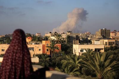 Una mujer observa el humo elevarse del sur de la Ciudad de Gaza luego de un bombardeo israelí, el martes.