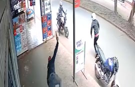 Momento en que el asaltante cae tras ser baleado por el dueño del local.