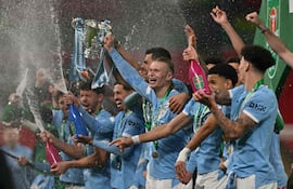 708
El delantero noruego del Manchester City, Erling Haaland, número 09, sostiene el trofeo mientras los jugadores del City celebran tras la final de la Copa de la Liga inglesa entre el Arsenal y el Manchester City en el estadio de Wembley en Londres el 22 de marzo de 2026. El City ganó el partido 2-0. (Foto de Glyn KIRK / AFP)
