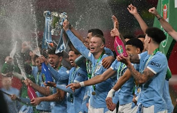 708
El delantero noruego del Manchester City, Erling Haaland, número 09, sostiene el trofeo mientras los jugadores del City celebran tras la final de la Copa de la Liga inglesa entre el Arsenal y el Manchester City en el estadio de Wembley en Londres el 22 de marzo de 2026. El City ganó el partido 2-0. (Foto de Glyn KIRK / AFP)