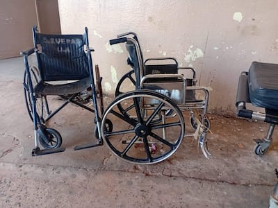 Tres sillas de ruedas alineadas contra la pared en un ambiente interior, mostrando desgaste y variabilidad en su estado.