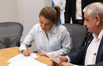La secretaria general del Sindicato Nacional de Médicos de Paraguay (Sinamed), Rossana González y el ministro de Salud de Paraguay, Isaías Fretes, firmando el acuerdo. Foto: EFE/ Presidencia de Paraguay.