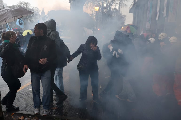 Personas son afectadas por el gas lacrimógeno durante una manifestación contra un proyecto de ley impulsado por el Gobierno de Javier Milei. Foto: Juan Ignacio Roncoroni - EFE.
