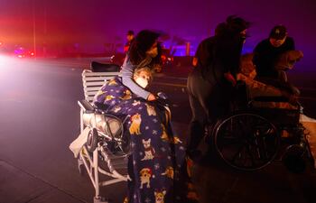 Los pacientes de edad avanzada son evacuados rápidamente a vehículos de emergencia mientras se acercan brasas y llamas durante el incendio de Eaton en Pasadena, California. Un violento incendio forestal se desató en un barrio exclusivo cerca de Los Ángeles, en la costa oeste de Estados Unidos, obligando a la evacuación de miles de personas desde el martes, con vientos huracanados que suponen un “peligro mortal”, según las autoridades.