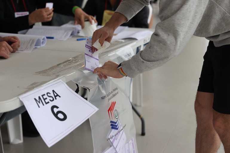 Una persona deposita un voto en un punto de votación este domingo, durante las elecciones municipales. EFE/ Juan Pablo Pino