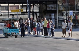 Personas esperan la llegada del transporte público, en una vía de la Habana (Cuba).
