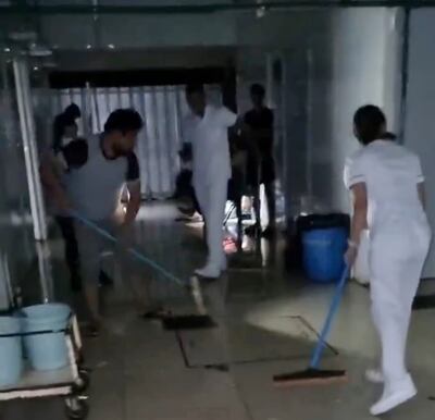 Los funcionarios del hospital tuvieron que escurrir para sacar el agua del pasillo del pabellón de contingencia.
