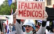 Una médica sostiene un cartel durante una protesta este lunes, en Asunción.