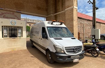 Furgón blanco con la inscripción 'Traslado de Internos' estacionado en la entrada de la penitenciaría, sin personas visibles.