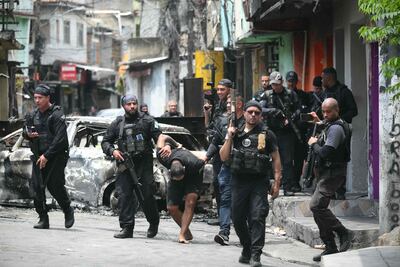 Agentes de policía escoltan a un sospechoso arrestado durante la Operación Contención fuera de la favela Vila Cruzeiro, en el complejo Penha, Río de Janeiro, Brasil.
