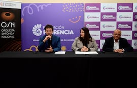 María Victoria Sosa atenta en abrigo claro, junto a un hombre de chaqueta azul hablando en conferencia en el Hotel Guaraní.