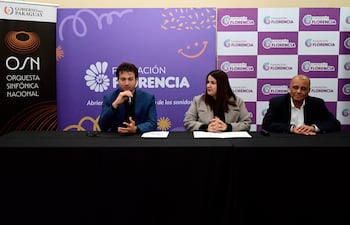 María Victoria Sosa atenta en abrigo claro, junto a un hombre de chaqueta azul hablando en conferencia en el Hotel Guaraní.