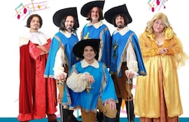 Seis personas vestidas con trajes de época, cuatro al frente y dos al fondo, con sombreros y espadas, en un ambiente festivo.