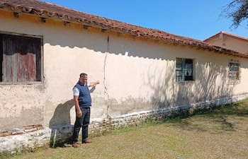 El director Osvaldo Ruiz señala una enorme fisura en la pared del pabellón en peligro derrumbe.