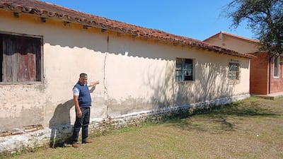 El director Osvaldo Ruiz señala una enorme fisura en la pared del pabellón en peligro derrumbe.