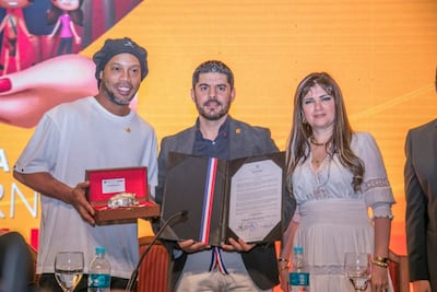 El exfutbolista, recibiendo una distinción por parte del Intendente de Asunción, en compañía de la empresaria Dalia López.