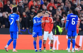 (FILES) SL Benfica's Argentine forward #25 Gianluca Prestianni hides his mouth while arguing with Real Madrid's Brazilian forward #07 Vinicius Junior who complained about alleged racists insults during the UEFA Champions League knockout round play-off first leg football match between SL Benfica and Real Madrid CF at Estadio da Luz in Lisbon on February 17, 2026. UEFA banned Benfica winger Gianluca Prestianni for six matches on April 24, 2026 after a controversial incident in the Champions League clash against Real Madrid in February. The European football governing body said they had taken the decision to ban the Argentine "for discriminatory (i.e. homophobic) conduct", with three of those matches suspended for a two-year probationary period. (Photo by PATRICIA DE MELO MOREIRA / AFP)