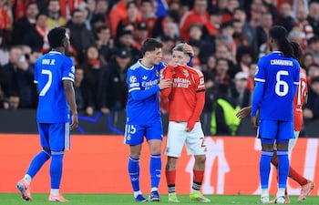 (FILES) SL Benfica's Argentine forward #25 Gianluca Prestianni hides his mouth while arguing with Real Madrid's Brazilian forward #07 Vinicius Junior who complained about alleged racists insults during the UEFA Champions League knockout round play-off first leg football match between SL Benfica and Real Madrid CF at Estadio da Luz in Lisbon on February 17, 2026. UEFA banned Benfica winger Gianluca Prestianni for six matches on April 24, 2026 after a controversial incident in the Champions League clash against Real Madrid in February. The European football governing body said they had taken the decision to ban the Argentine "for discriminatory (i.e. homophobic) conduct", with three of those matches suspended for a two-year probationary period. (Photo by PATRICIA DE MELO MOREIRA / AFP)