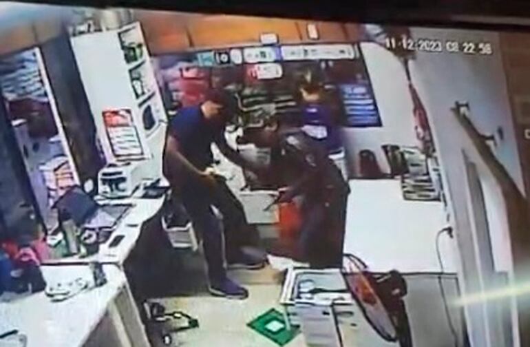 Los dos delincuentes armas en mano cargan fajos de dinero en una bolsa de hule y escapan.