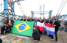 Grupo de personas con banderas de Brasil, Chile y Paraguay en el puente de la bioceànica