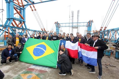 Grupo de personas con banderas de Brasil, Chile y Paraguay en el puente de la bioceànica