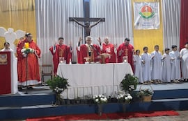 El cardenal Adalberto Martínez en el altar, vestido de rojo, rodeado de niños en túnicas blancas y otros sacerdotes en un ambiente solemne.