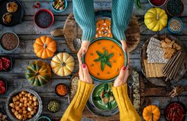 Manos sosteniendo una sopa de invierno.