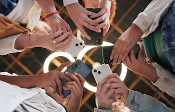 Personas usando sus smartphones, mirando sus redes sociales, imagen ilustrativa.