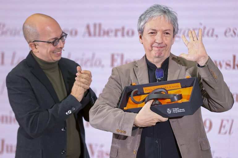 El escritor David Toscana (derecha) posa con la escultura que forma parte del Premio Alfaguara, que recibió hoy en Madrid por su obra 'El ejército ciego'. El escritor mexicano Jorge Volpi (izquierda) presidió el jurado.