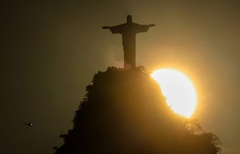 Fotografía que muestra la puesta de sol detrás del monumento del Cristo Redentor en Río de Janeiro (Brasil).