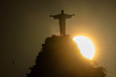 Fotografía que muestra la puesta de sol detrás del monumento del Cristo Redentor en Río de Janeiro (Brasil).