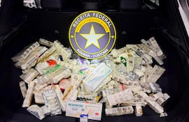 Paquetes de medicamentos apilados en el maletero de un vehículo, con distintivo de la Receita Federal de Brasil.