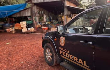 Vehículo de la Policía Federal con logotipo visible, estacionado junto a un galpón de madera en un entorno rural.