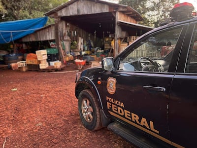 Vehículo de la Policía Federal con logotipo visible, estacionado junto a un galpón de madera en un entorno rural.