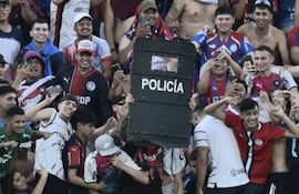 Uno de los barrabravas de Cerro Porteño exibe el escudo que fue despojado de un policía durante el superclásico Cerro Porteño Olimpia el domingo pasado.