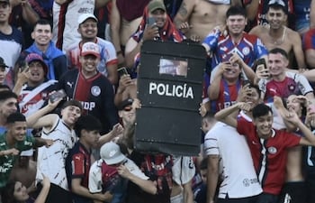 Uno de los barrabravas de Cerro Porteño exibe el escudo que fue despojado de un policía durante el superclásico Cerro Porteño Olimpia el domingo pasado.