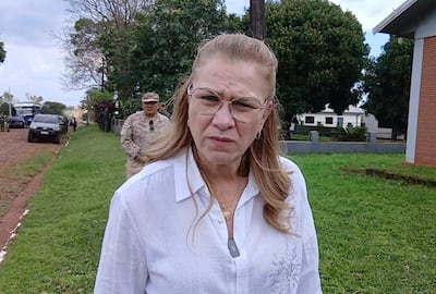 María Teresa Barán con cabello largo y rubio, vista en primer plano, mientras un hombre en segundo plano observa con atención.