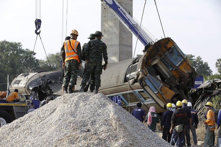 
Rescatistas trabajan en los restos de un tren de pasajeros tras el desplome de una grúa de construcción sobre él en el distrito de Sikhio, Nakhon Ratchasima, Tailandia, el 14 de enero de 2026. 
