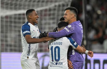 El guardameta de Liga de Quito, Gonzalo Valle, celebra junto a sus compañeros de equipo, el defensa haitiano Ricardo Adé y el centrocampista Alexander Alvarado, tras ganar la tanda de penaltis del partido de vuelta de los octavos de final de la Copa Libertadores de fútbol entre el Liga de Quito de Ecuador y el Mirassol de Brasil, en el estadio Rodrigo Paz Delgado.