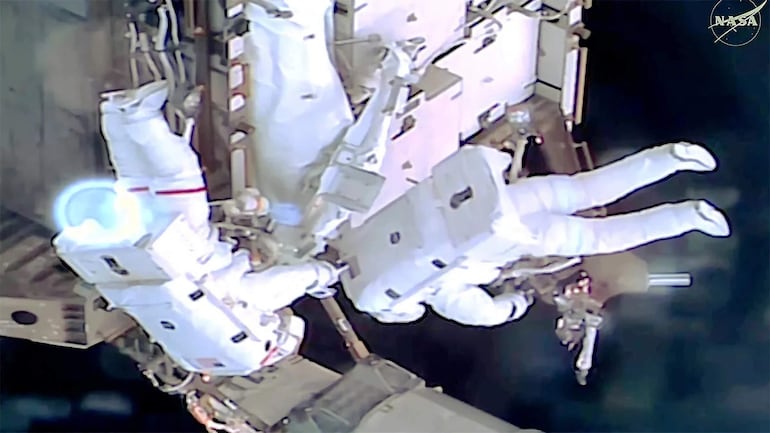 Captura de vídeo cedida por NASA + donde aparecen los astronautas de la NASA Jessica Meir y Anil Menon trabajando en el exterior de la Estación Espacial Internacional (EEI), durante una caminata espacial para instalar equipos destinados a futuras actualizaciones del sistema de energía.