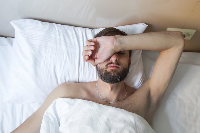 Hombre cansado en la cama.
