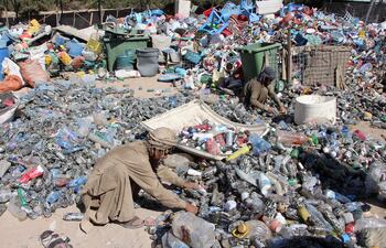 Trabajadores afganos recogen y clasifican botellas y envases de plástico desechados para su reciclaje en Kandahar, Afganistán, el 14 de octubre de 2026. (Afganistán)