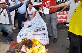 Integrantes de la Corriente Sindical Clasista (CSC) se manifestaron hoy frente al MTESS y realizaron una quema simbólica del acuerdo que firmaron algunas centrales obreras con el presidente Santiago Peña