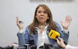 Celeste Amarilla con chaqueta de mezclilla y blusa blanca, sosteniéndose de un micrófono mientras levanta una mano con énfasis.